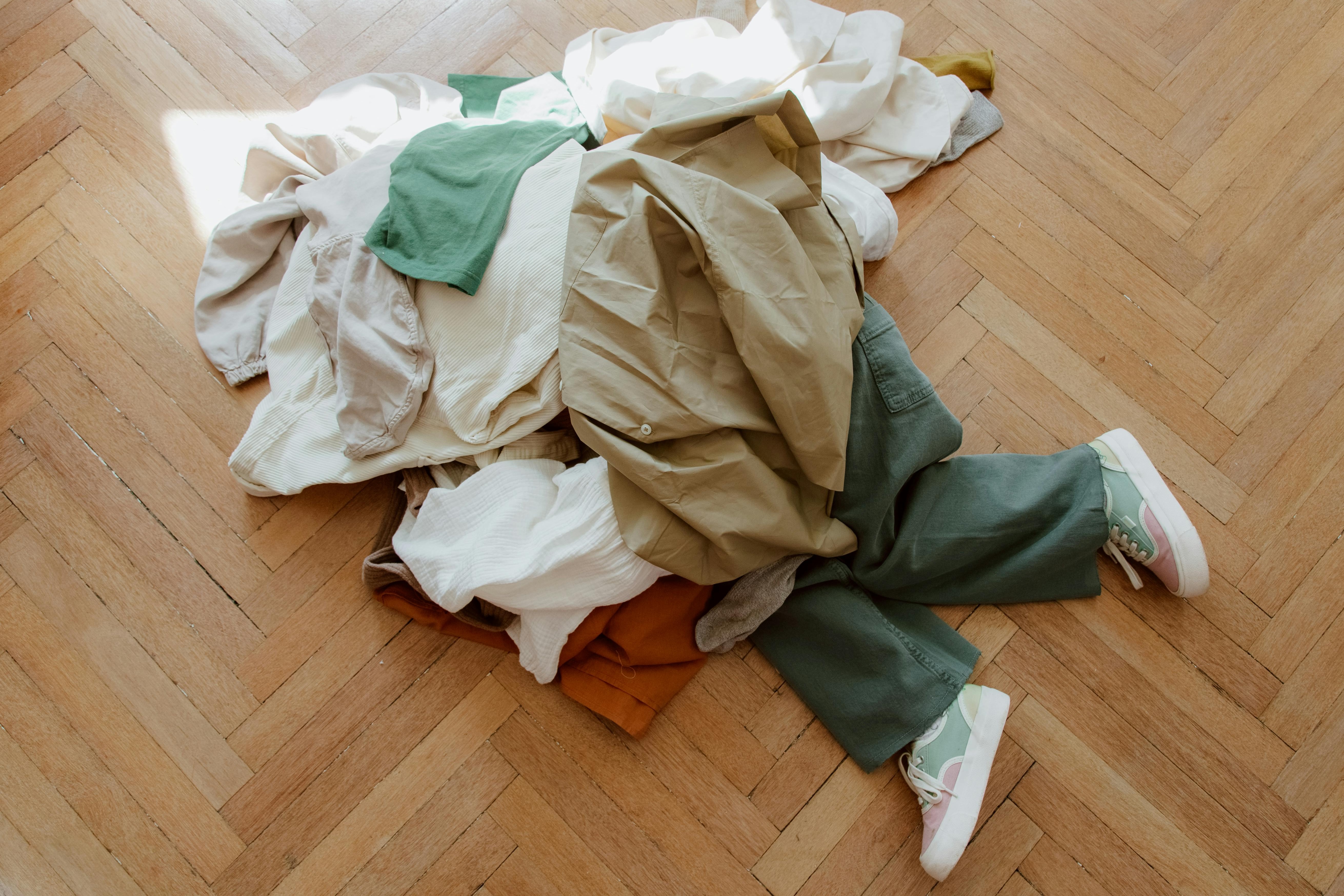 picture of a person buried under a pile of clothes 