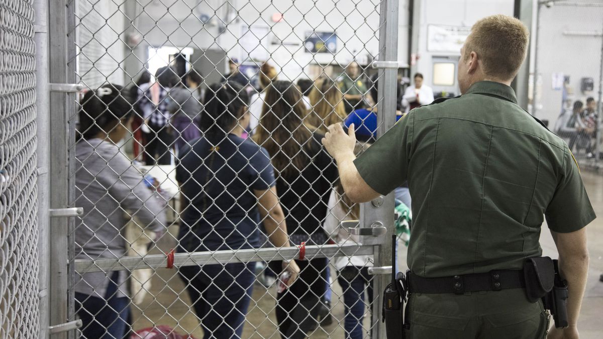 Photo of a detention centre depicting a guard looking at detainees from the back