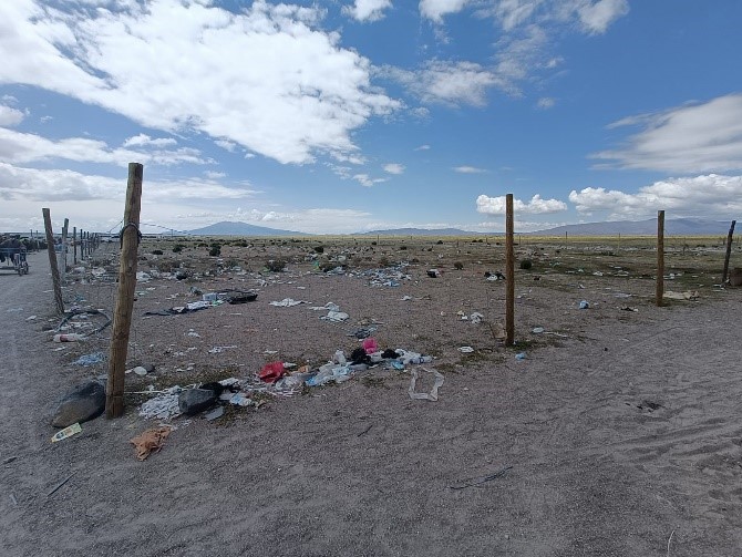 A fenced border area with a lot of litter