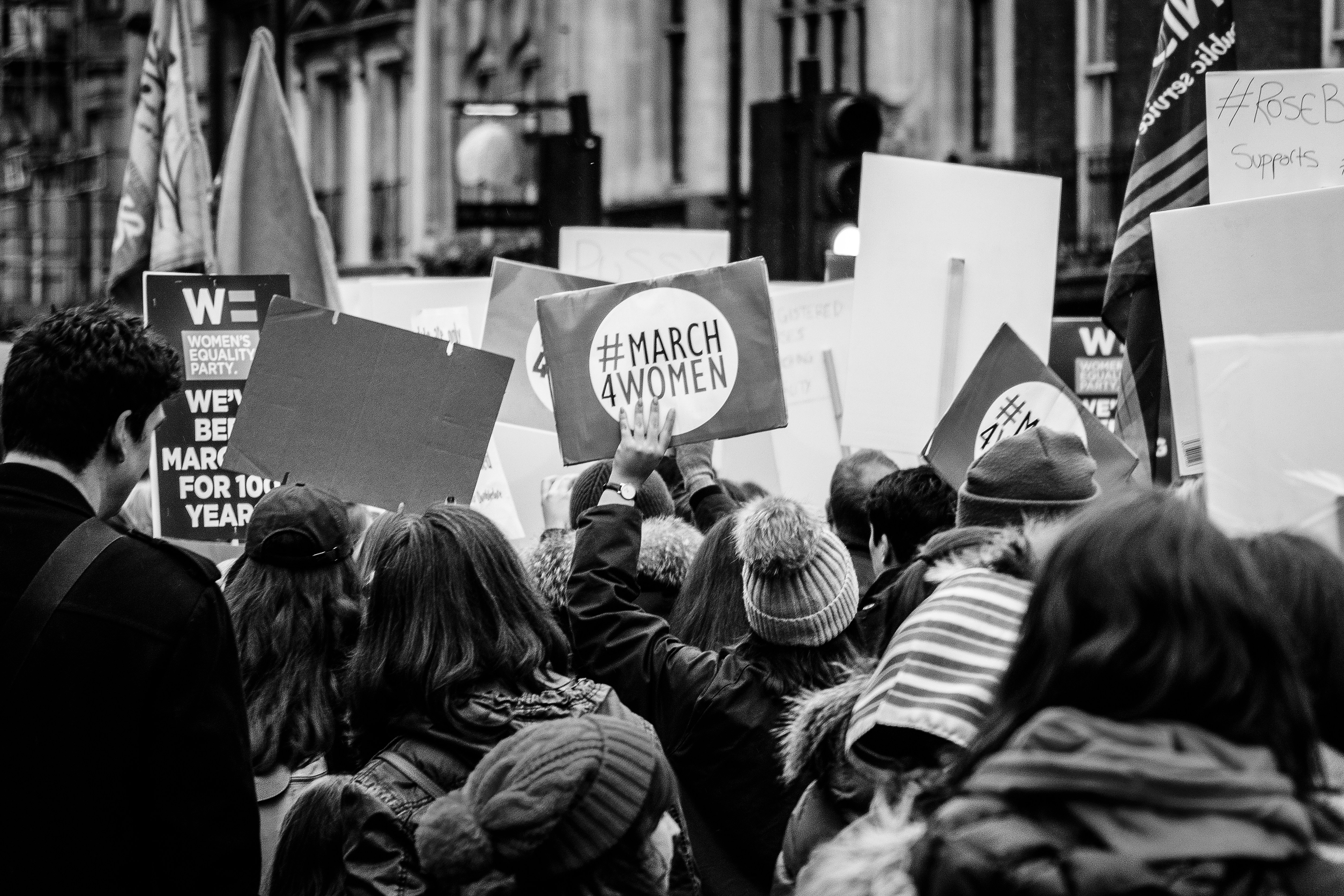 picture from a protest with someone holding a sign that says 'March4Women' 