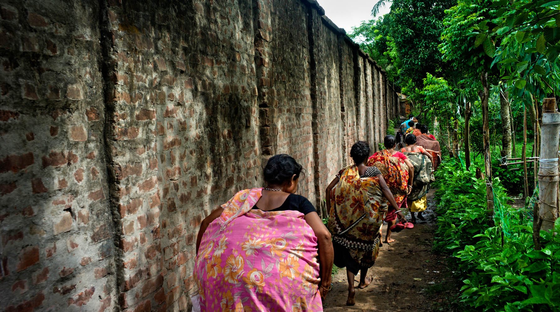 Women walking by a wall 