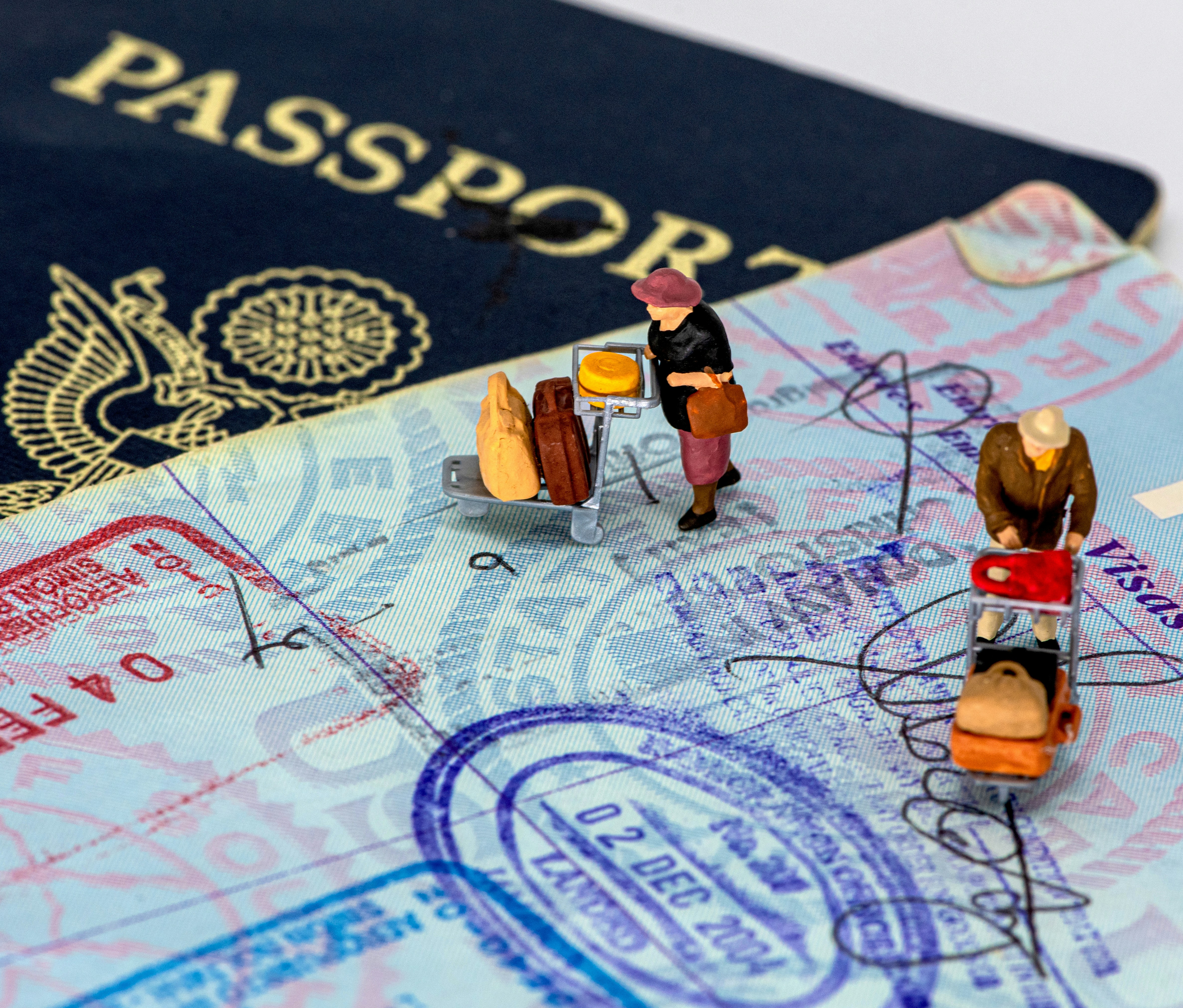 2 men in yellow and black suit action figures over a passport