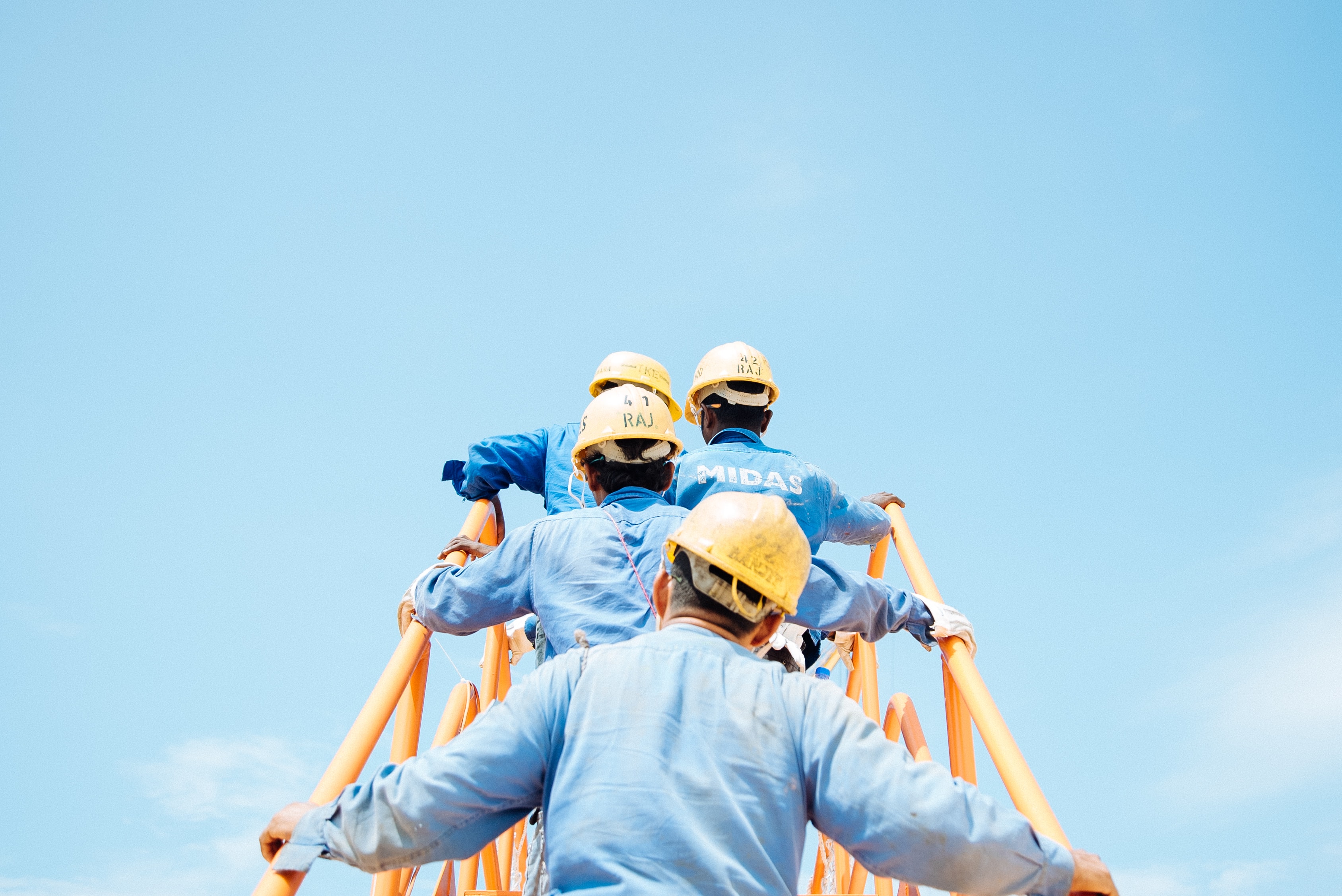 Construction workers in front of a blue sky