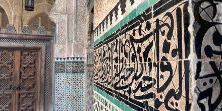 The calligraphy on the wall and the walls with rich and fine stucco geometric shapes and wood carvings are both from the Bou Inania Complex in Fes