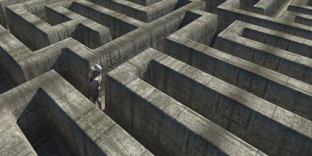 picture taken from above of a person inside a labyrinth, looking towards the left side of the picture, at a wall 