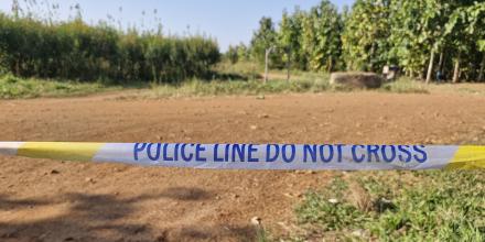 picture of a field with a tape in front of it that says "police do not cross"