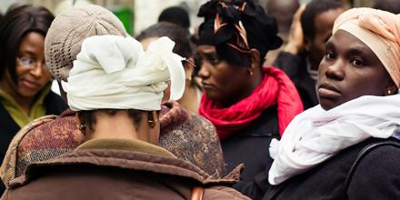 picture of a few women seen from the back, with one on the right who is looking to the left of the photographer