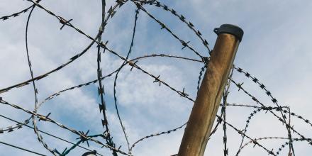 Picture of a barbed wire against a background of a blue sky
