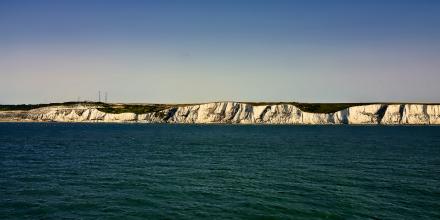 White cliffs of Dover with the sea in the foreground, and blue sky above the cliffs
