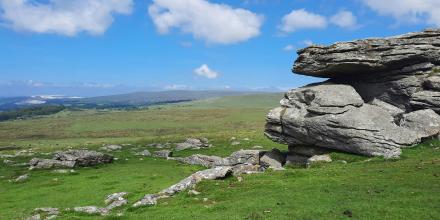 Green hills and a boulder in Dartmoor.