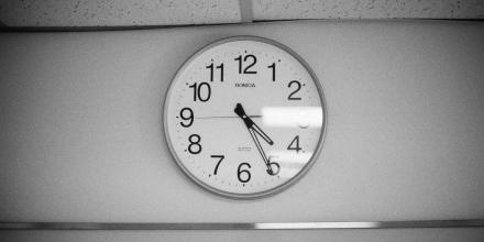 A plain clock face on a white wall.