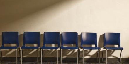 A row of chairs against a plain wall.