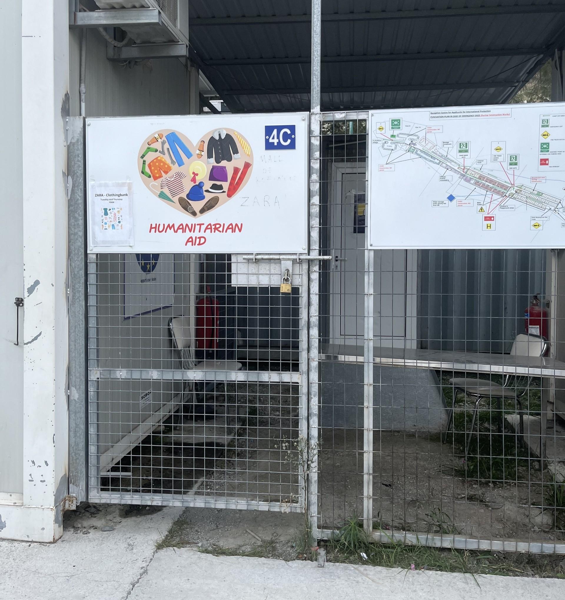 Photo of a humanitarian aid distribution point at a reception centre in the RoC, showing a gate with a sign that says 'humanitarian aid'