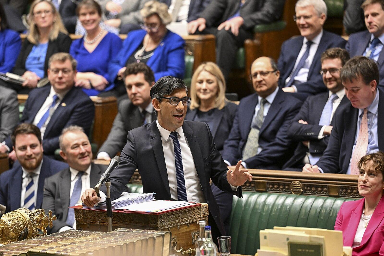 The former UK prime minister Rishi Sunak speaks during a debate in parliament, gesticulating and smiling