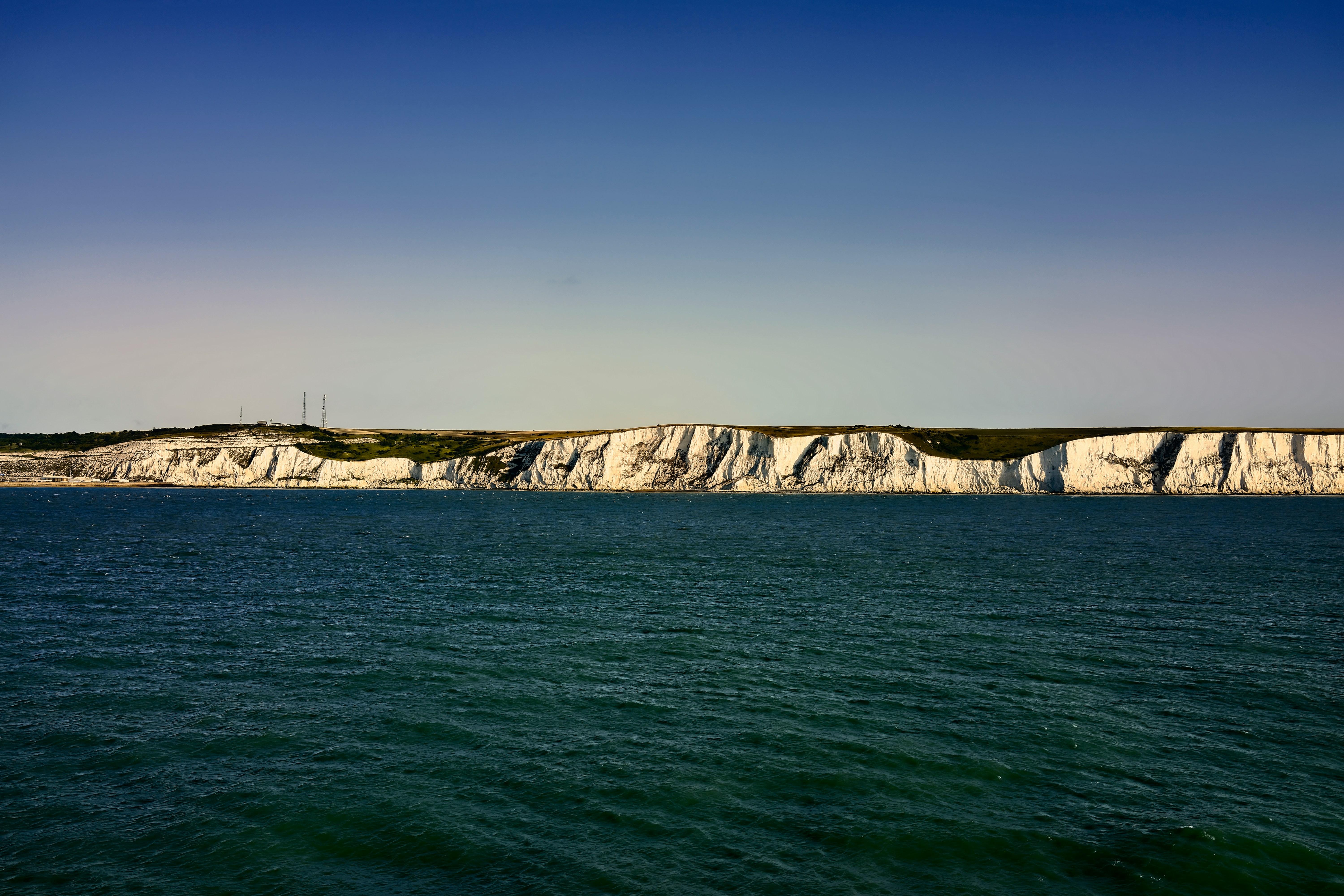 White cliffs of Dover with the sea in the foreground, and blue sky above the cliffs