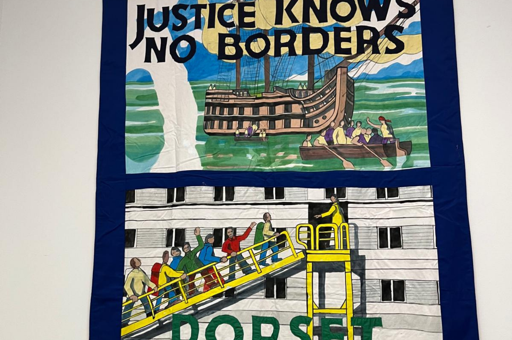 A photograph of a tapestry hanging on a wall depicting people waving as they walk up a gangway onto a ship. It reads 'Justice knows no borders' at the top and 'Dorset' at the bottom