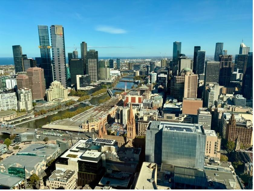The Melbourne skyline during the day, showing various high rise buildings and ongoing construction on a sunny day. 